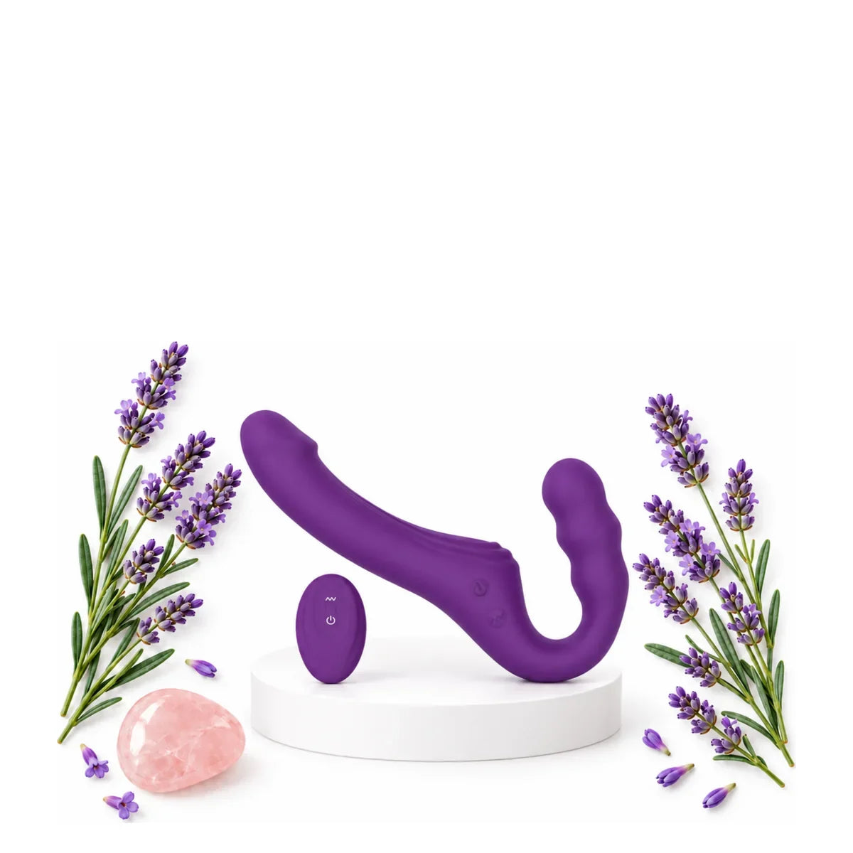 Violetter, doppelseitiger Strap-on-Dildo mit Fernbedienung auf einem weißen Podest zwischen Lavendelzweigen.