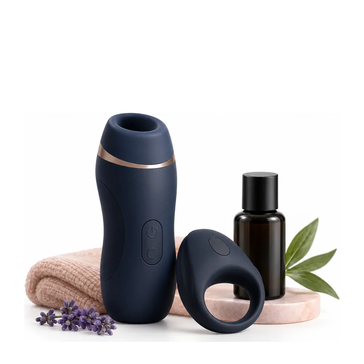 Dunkelblauer Masturbator und Penisring neben einer braunen Flasche, einem Handtuch und Lavendel.